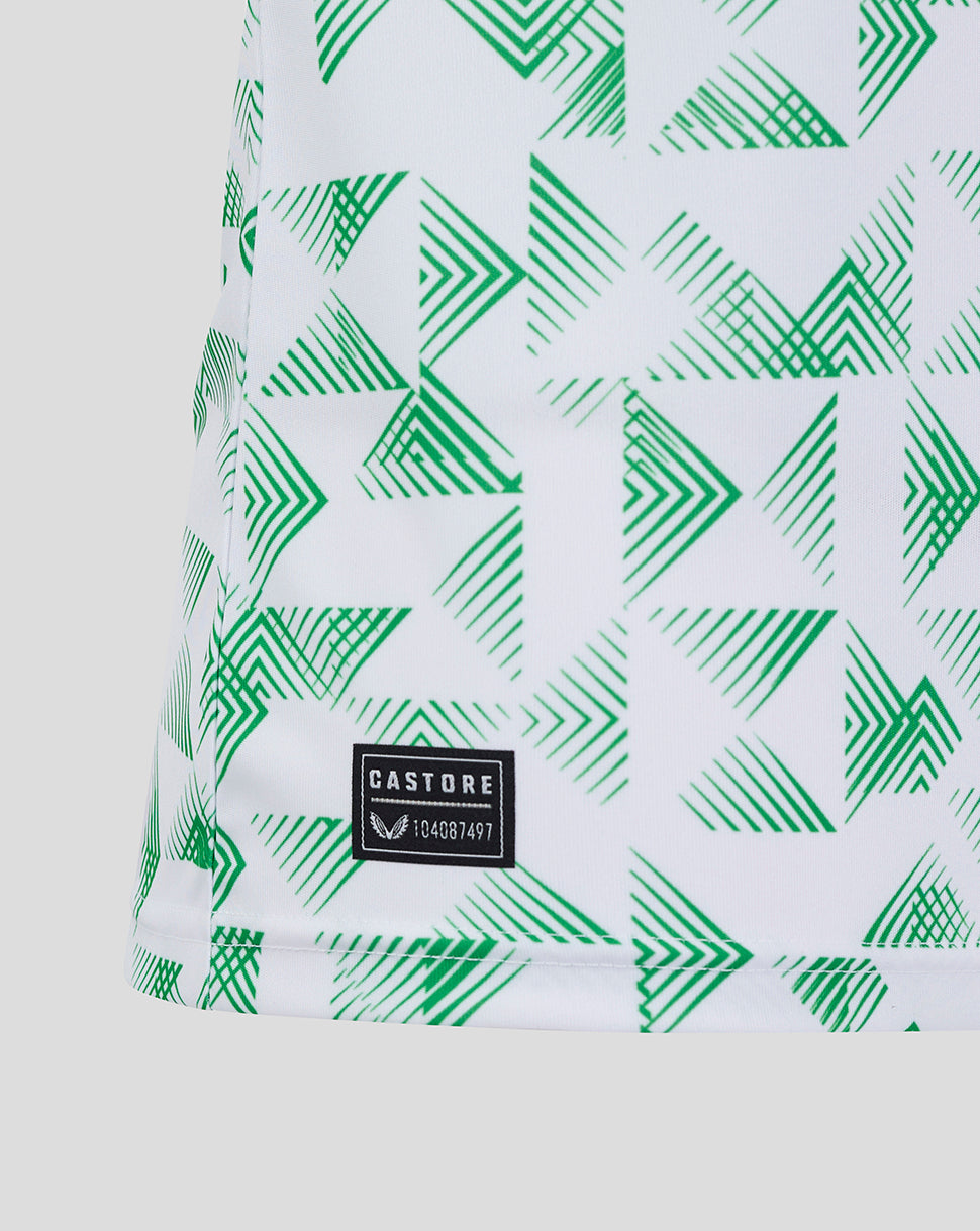 Close up of Mansfield Away Shirt fabric with white base and green geometric chevron print plus Castore patch.