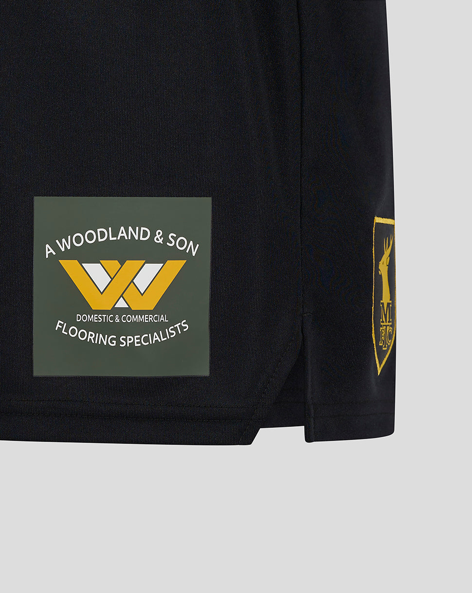 Lower leg of Mansfield Third Shorts featuring a green sponsor patch with white text and a yellow logo.