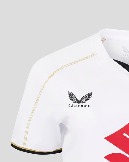 Close up of the white MK Dons shirt sleeve showing gold piping and Castore logo on the chest