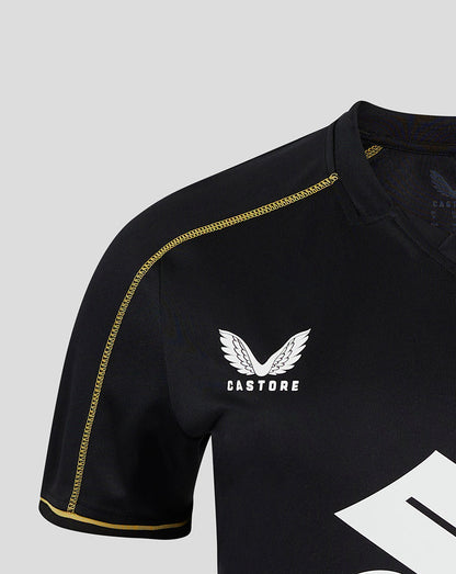 Black Mk Dons women's 24/25 third shirt with gold piping along the shoulder and a white winged crest under Castore branding