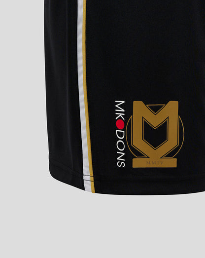 Close up of black Mk Dons shorts showing gold crest and vertical MK DONS lettering along the side