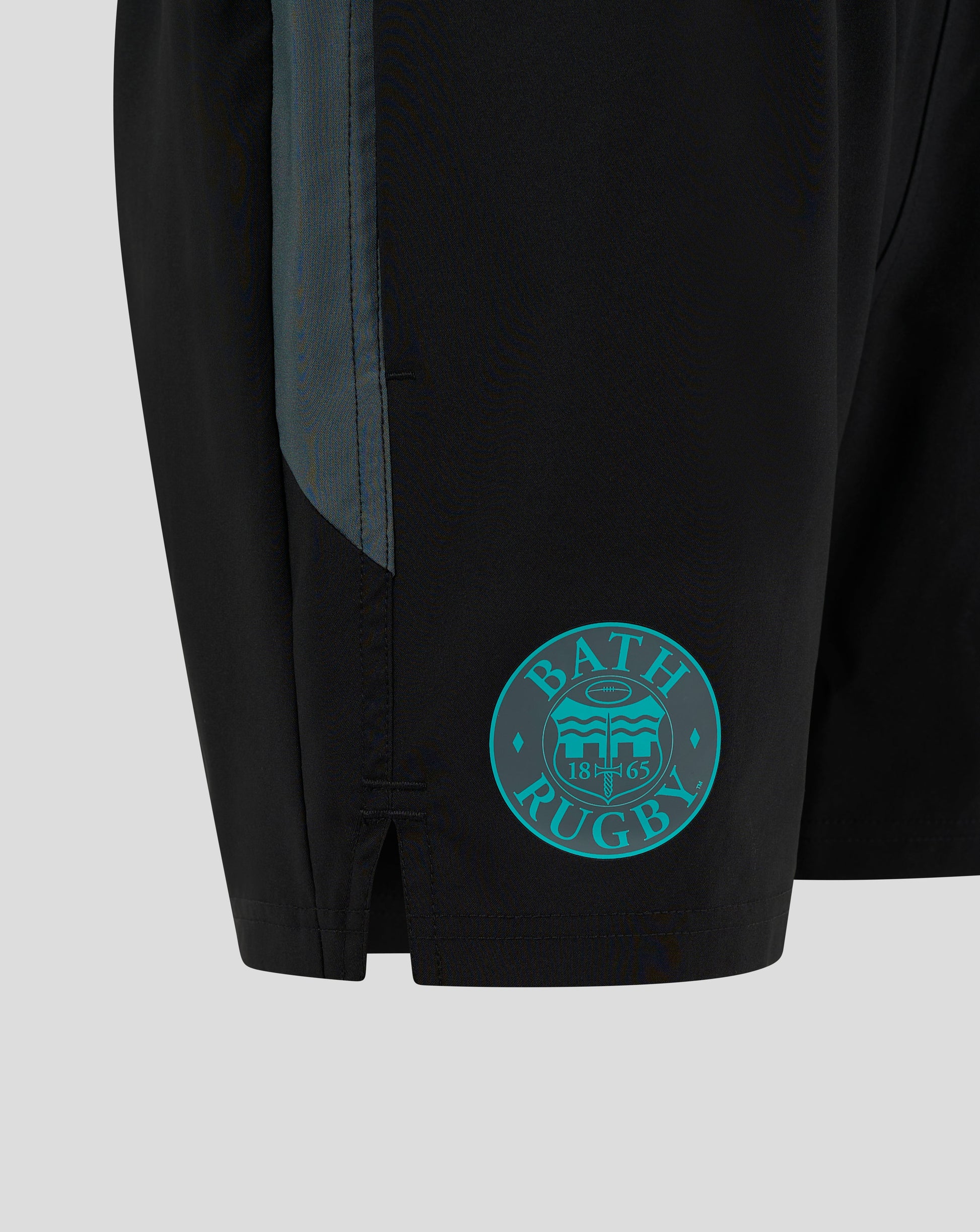 Close up of Bath Rugby Shorts showing teal side panel and Bath crest badge near the hem.
