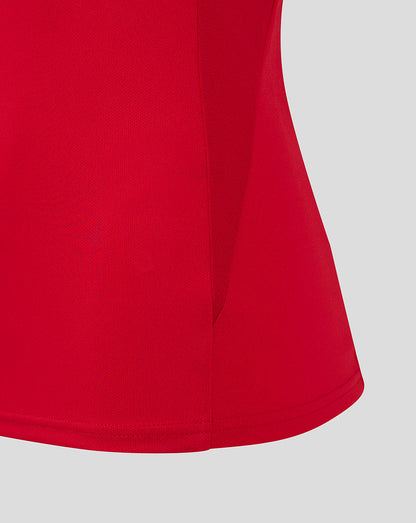 Close-up of red polo fabric showing side seam and curved hem on the Scarlets Pro Players polo