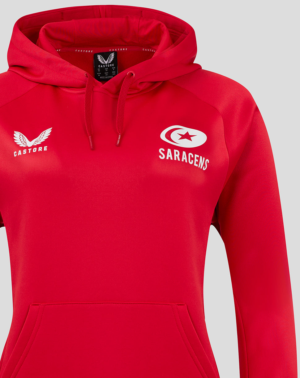 Close-up of the red training hoodie chest showing Castore logo on the left and Saracens emblem on the right.
