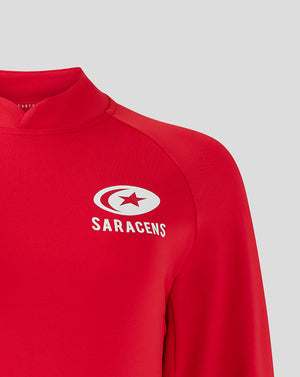 Close up of red Saracens training top with white Saracens logo on the chest