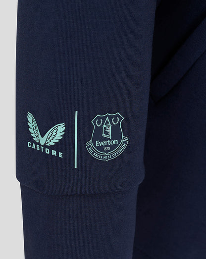 Close-up of navy fabric featuring light blue Castore logo and Everton crest on the sleeve