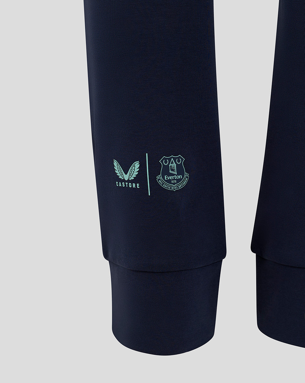 Close-up of navy travel pant leg showing Castore logo and Everton crest near the lower leg cuff.