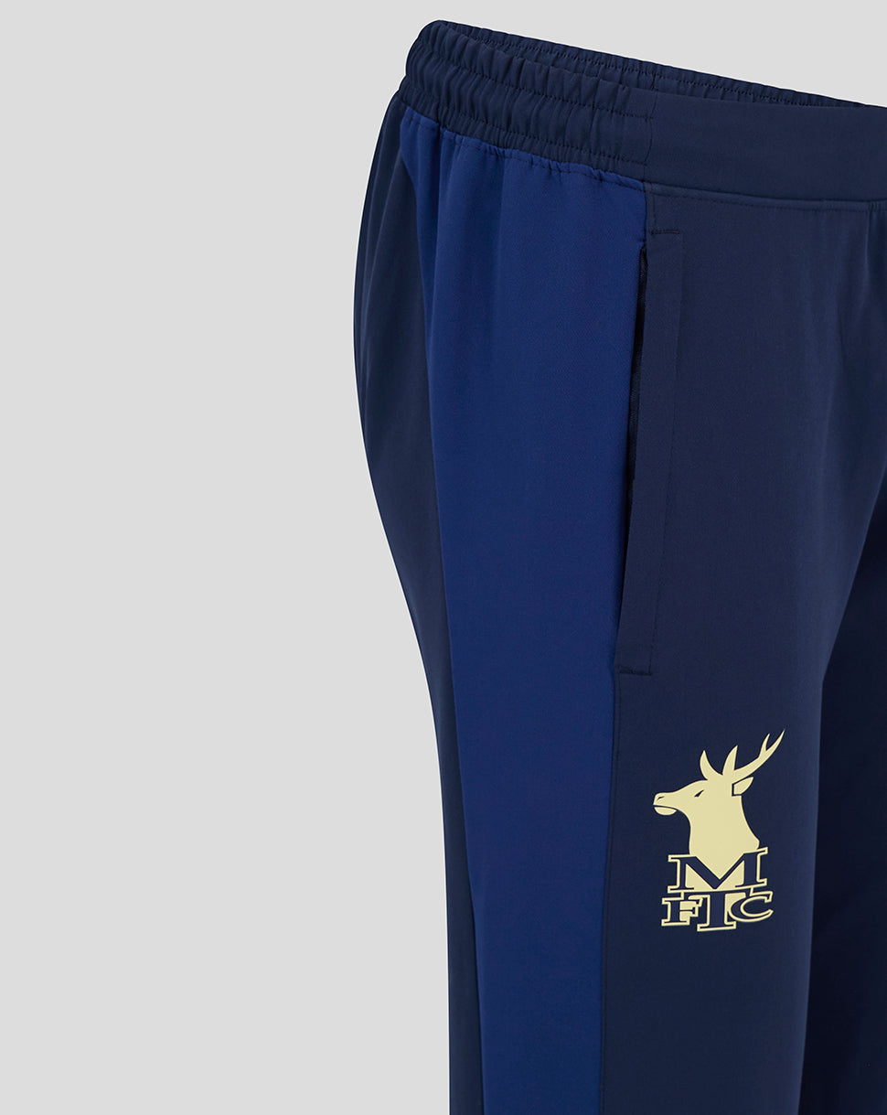 Close-up of the lower leg showing the gold deer emblem on navy Mansfield training pants.