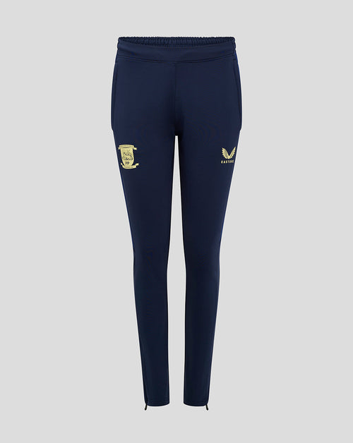 Front view of navy training pants with gold crest on the thigh and Castore logo, ankle zippers.