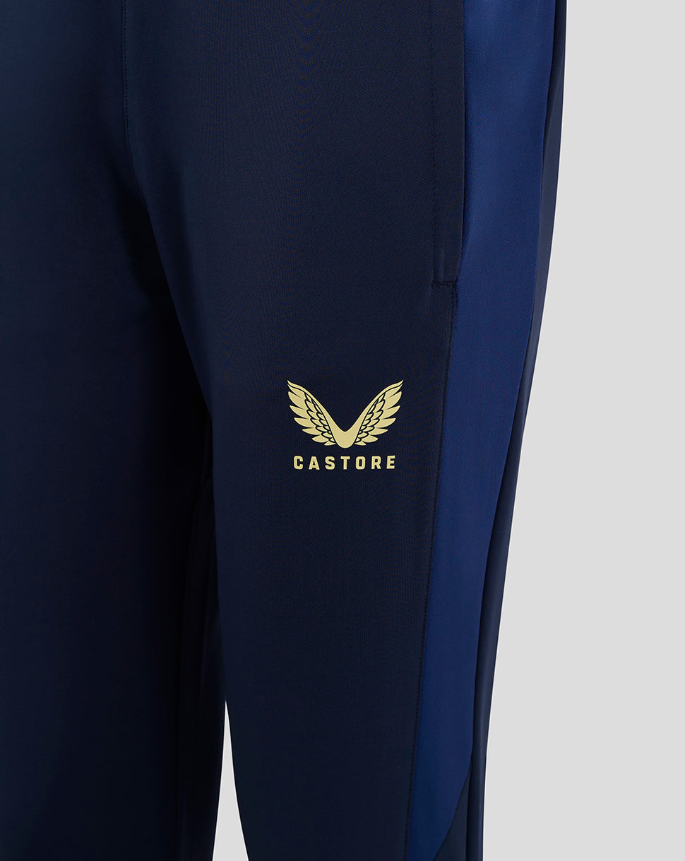 Close up of navy Preston NE training pants showing gold club crest on right thigh and Castore logo on left thigh