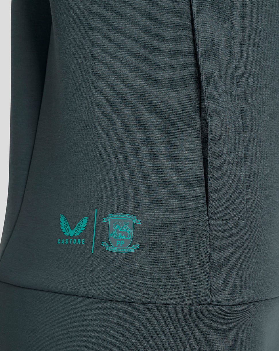 Close-up of teal Castore logo and Preston North End crest on the lower side of the hoodie