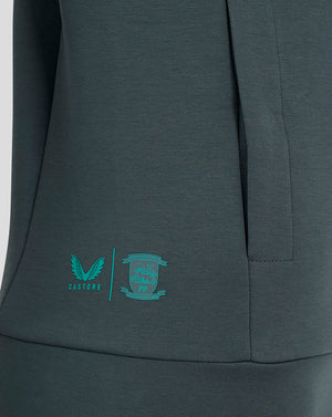 Close-up of teal Castore logo and Preston North End crest on the lower side of the hoodie