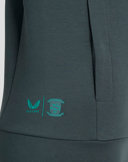 Close-up of teal Castore logo and Preston North End crest on the lower side of the hoodie