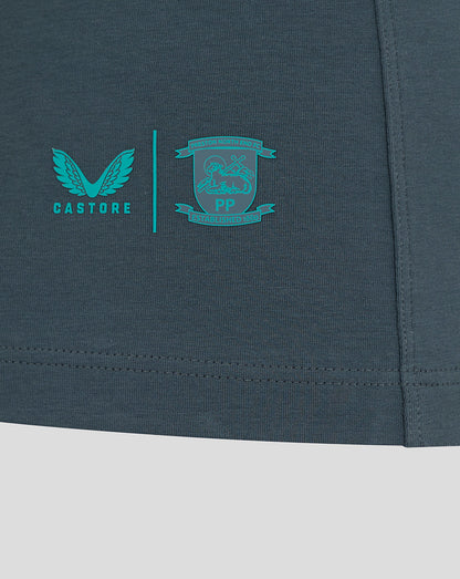 Close up of teal Castore logo and the Preston North End crest near the lower right hem of the polo