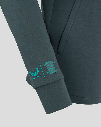 Close up of chest showing teal wing logo and Castore branding along the collar