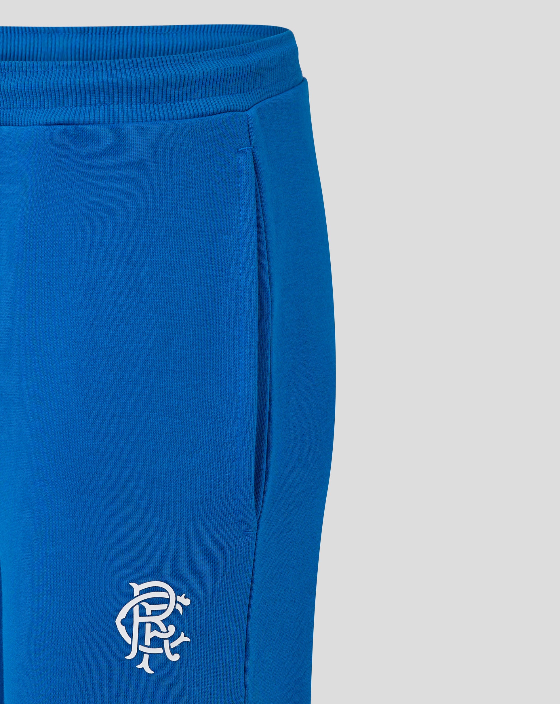 Close-up of blue Rangers FC Core Joggers showing elasticated waistband with drawcord and crest on left thigh