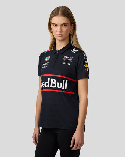 Front view of a woman in a navy Red Bull Racing polo with chest logos and sponsor patches