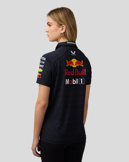 Back view of a female model wearing a night sky navy Red Bull Racing polo featuring a large Red Bull logo on the back