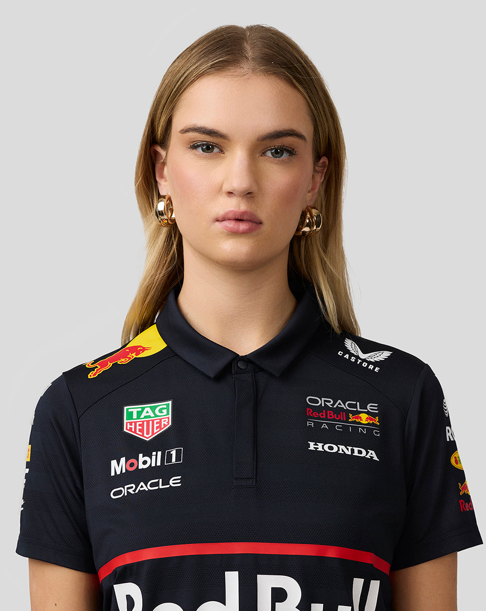 Close up of a model wearing the night sky navy Red Bull Racing polo highlighting chest logos and collar details