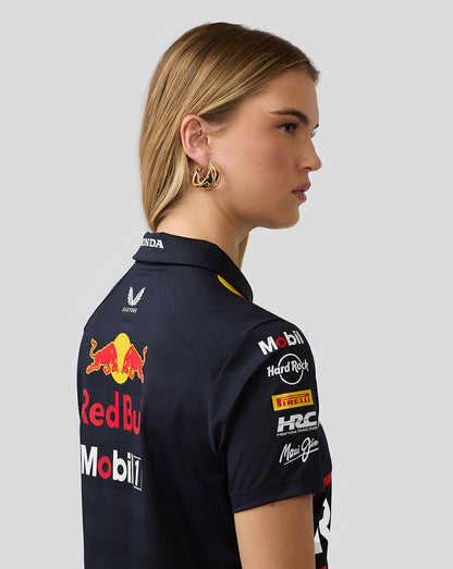 Side profile of a woman wearing a night sky Red Bull Racing polo with back branding