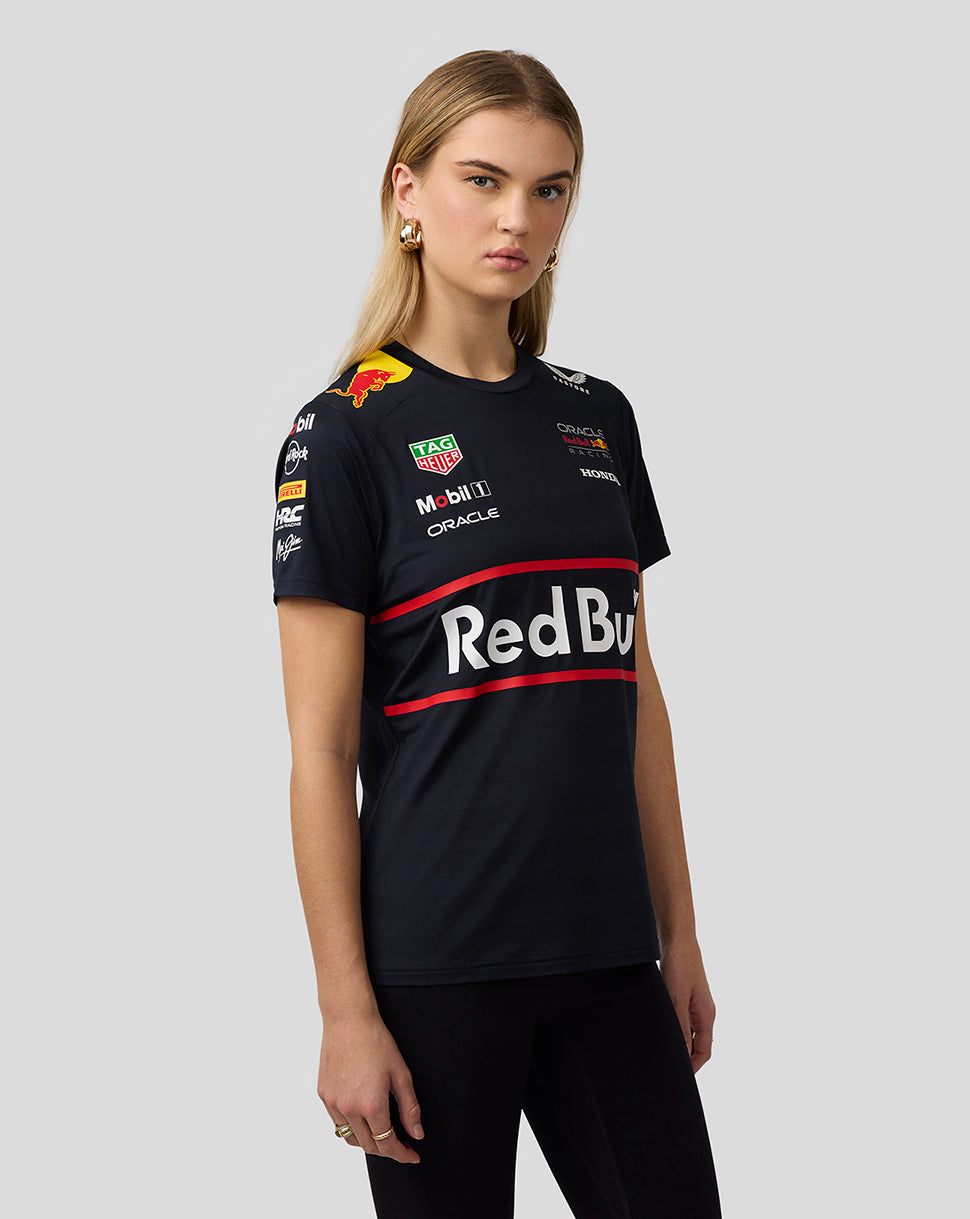 Three-quarter front view of a woman in a navy Red Bull Racing Set Up T Shirt with large chest logo and sponsor patches.