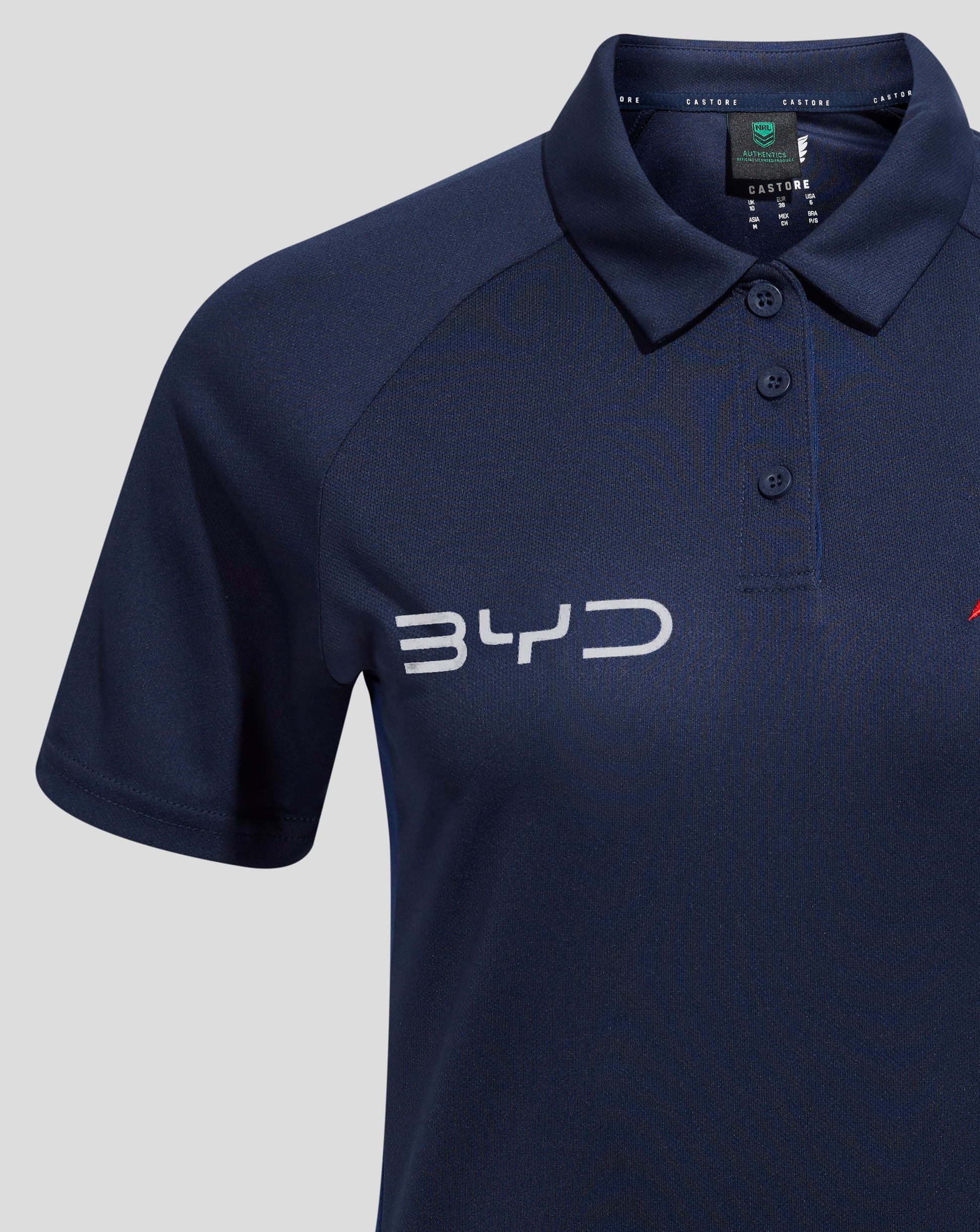 Collar close up of navy polo with a three button placket and Castore branding visible on the neck tape.