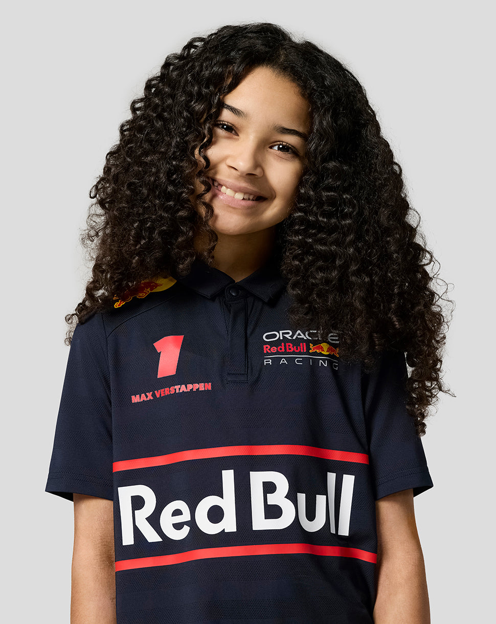 Young girl wearing a Night Sky Oracle Red Bull Racing junior polo with Verstappen artwork and team logos