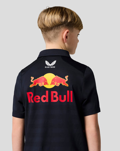 Back view of a child wearing a night sky navy Red Bull Racing junior polo with a large Red Bull graphic and Castore branding on the back