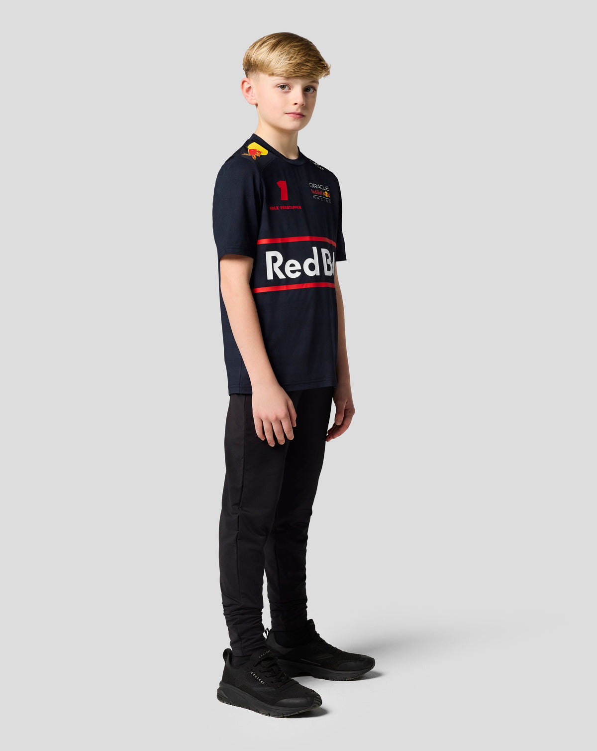 Young boy wearing navy Oracle Red Bull Racing Junior Teamline T shirt with Verstappen number 1 and team branding