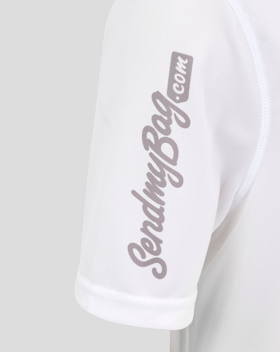 Close up of white Ulster junior home shirt sleeve with light gray script logo along the arm
