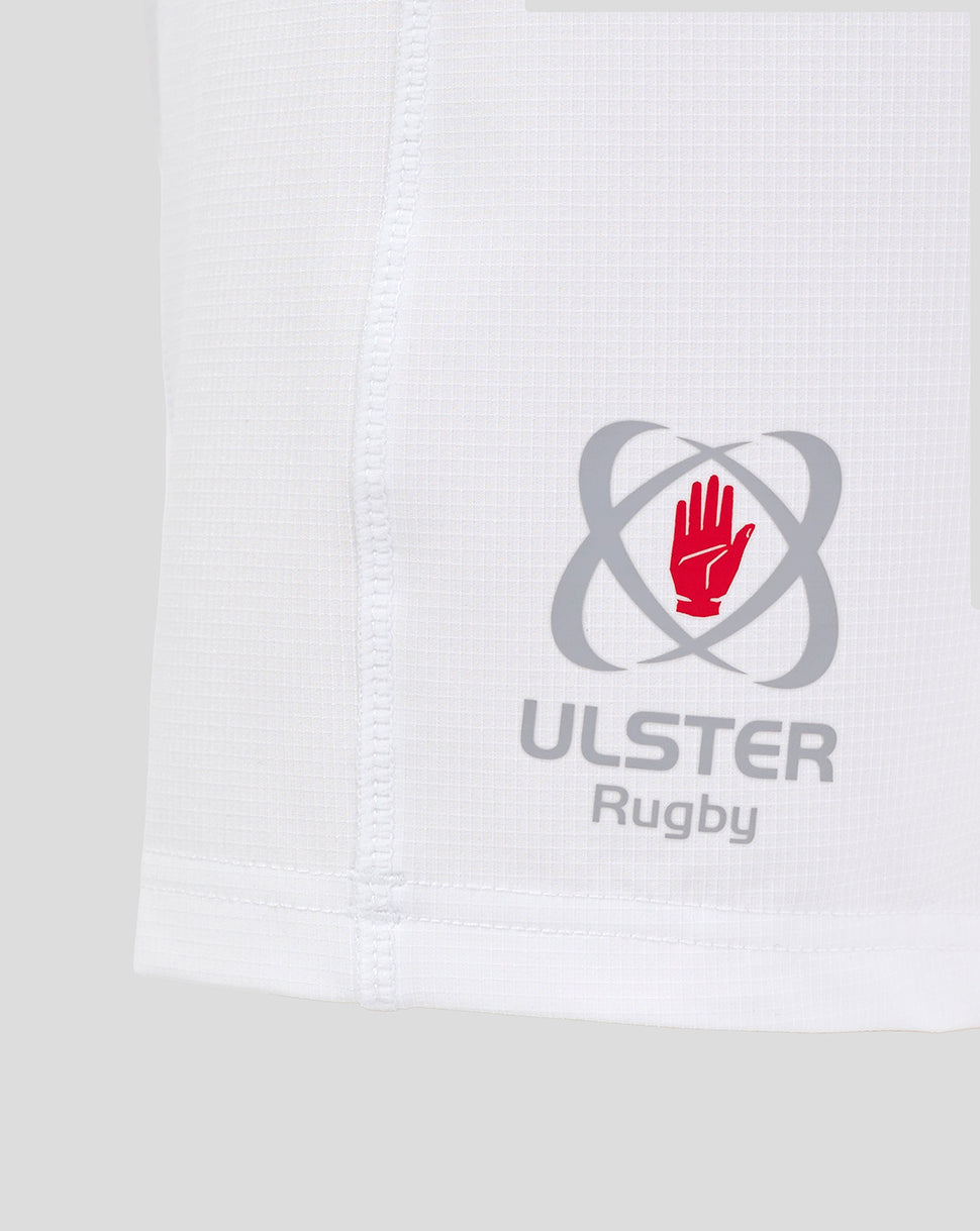 Close up of white Ulster Rugby junior home shorts showing the logo with red hand emblem near the hem