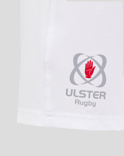Close up of white Ulster Rugby junior home shorts showing the logo with red hand emblem near the hem