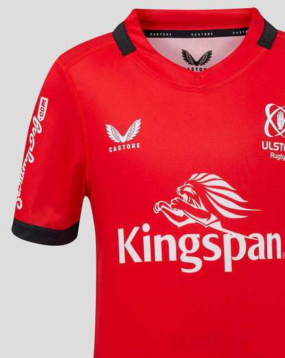 Close-up of Ulster Junior away jersey highlighting Kingspan sponsor and crest on red fabric.