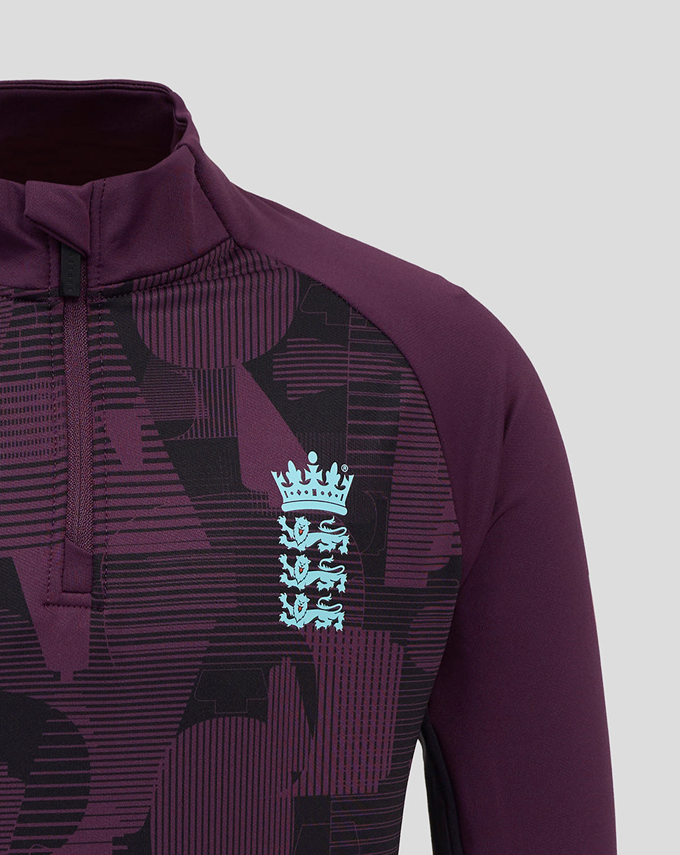 Chest close up of the purple England junior top with a light blue Castore crest against geometric print.