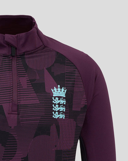 Chest close up of the purple England junior top with a light blue Castore crest against geometric print.