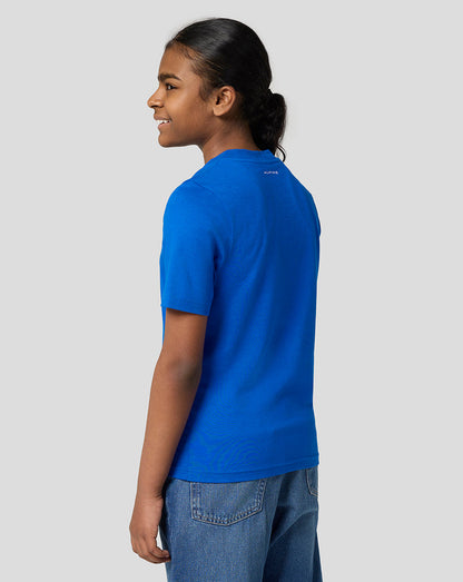 Back view of a girl wearing a lapis blue Alpine Core Essentials T shirt with a small Alpine logo at the upper back