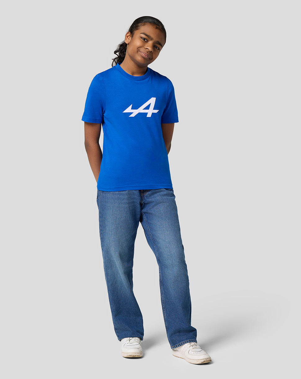 Front view of a smiling girl in lapis blue Alpine Core Essentials T shirt with a large white logo on the chest