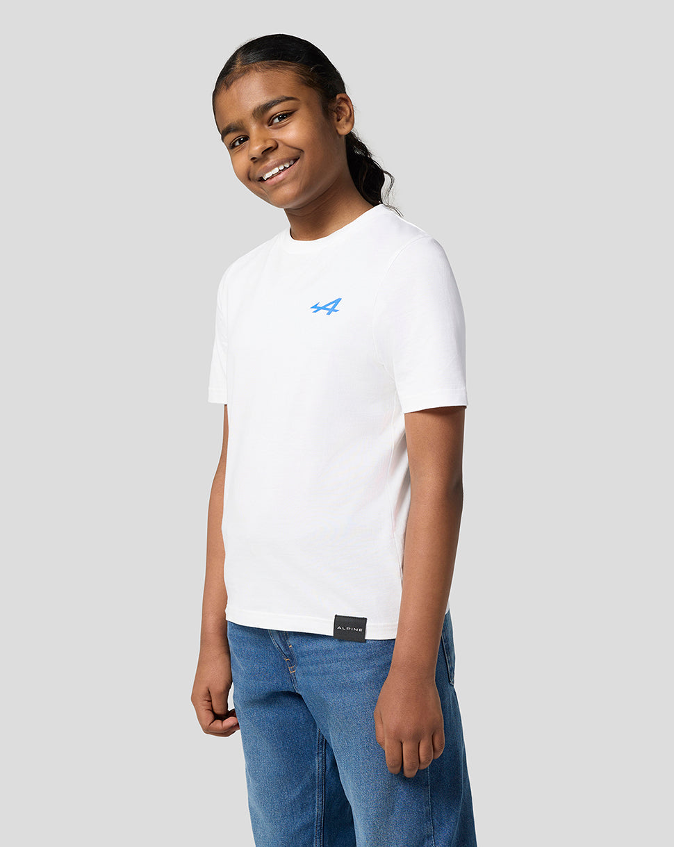 Young model in white Alpine Juniors Graphic T-Shirt with blue left chest logo and hem tag.