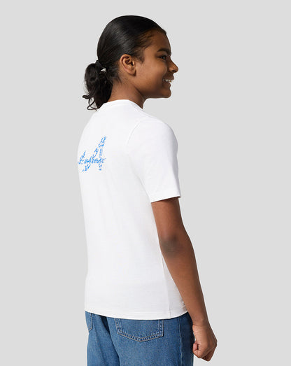 Side view of a child wearing a white Alpine Juniors Graphic T-Shirt with a blue logo on the back.