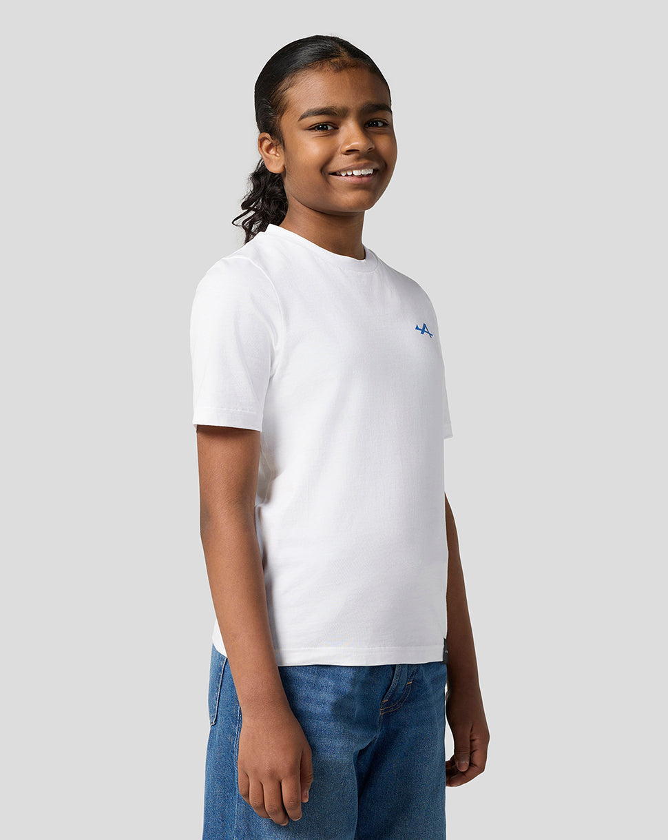 Child wearing Alpine Juniors white graphic T shirt with small blue logo on the left chest.