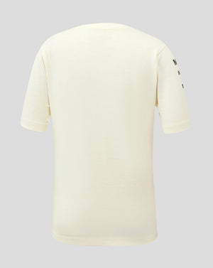 Back view of a cream colored Junior Heritage Team T Shirt with branding on the sleeve