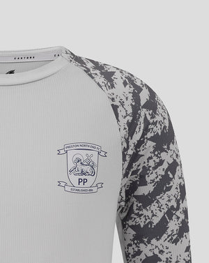 Close-up of upper chest showing club crest on light grey fabric and camo patterned sleeve