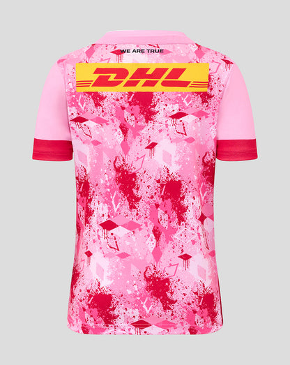 Back view of pink Harlequins junior away shirt with large DHL logo across the back and splatter print.