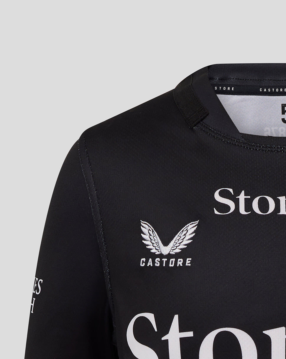 Front view close-up of black Saracens Junior 25/26 Replica Home Shirt showing crest and Castore branding.