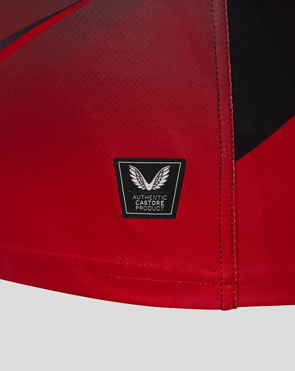 Close-up of red Saracens replica shirt fabric with a black authentic Castore product badge