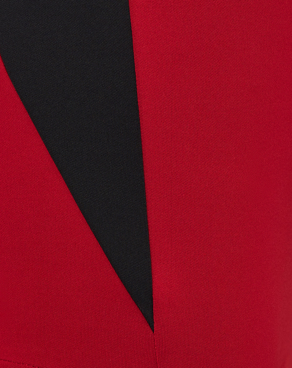 Close-up of red and black colorblock fabric with geometric pattern on Saracens training top sleeve.