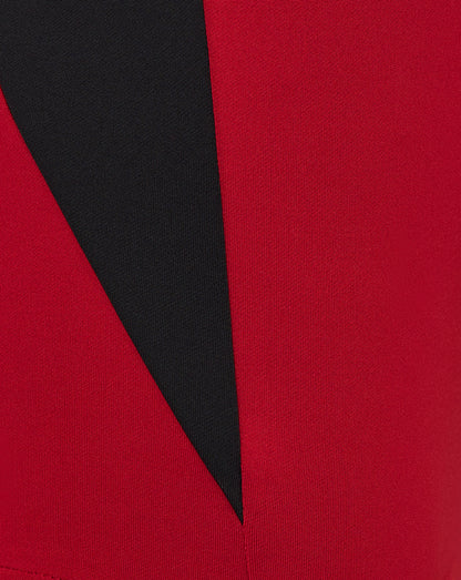Close-up of red and black colorblock fabric with geometric pattern on Saracens training top sleeve.