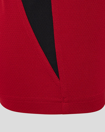 Red training tee hem with black diagonal side panel and crisp stitching