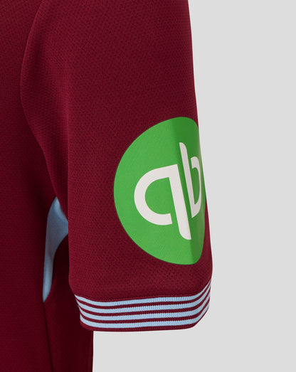 Close-up of burgundy sleeve with a bright green sponsor patch on the West Ham junior home shirt