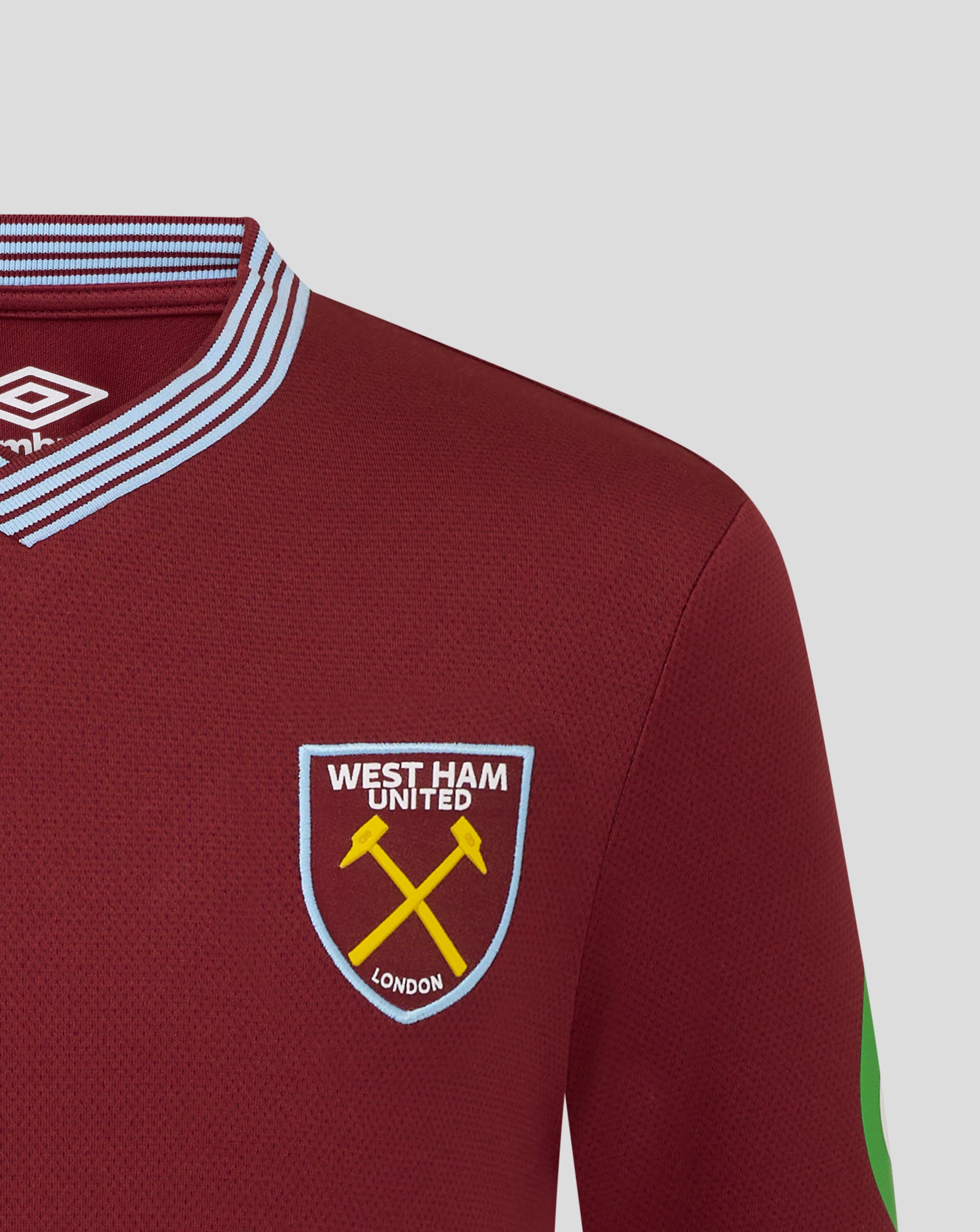 Close up of maroon West Ham Junior 25/26 shirt collar with light blue striped trim and West Ham United crest